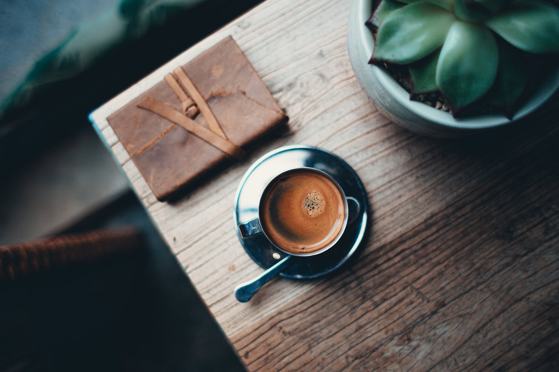 Notizbuch und Kaffeetasse auf einem Holztisch, Lernzeit im Fernstudium dokumentieren statt neu planen